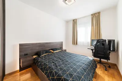 a bedroom with a bed and a desk and a television at Aurora 2 Apartment with Garage in Budva