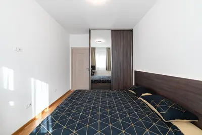 a bedroom with a large bed and a mirror at Aurora 2 Apartment with Garage in Budva