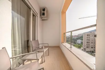 a balcony with two chairs and a large window at Aurora 2 Apartment with Garage in Budva