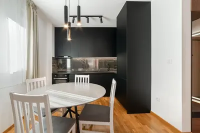 a dining room with a white table and chairs at Aurora 2 Apartment with Garage in Budva