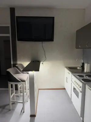 a kitchen with a table and a tv on the wall at Petar Marstijepović in Bar, Susanj