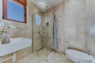 a bathroom with a shower and a toilet and a sink at Lotos - stan 310 in Dobra Voda