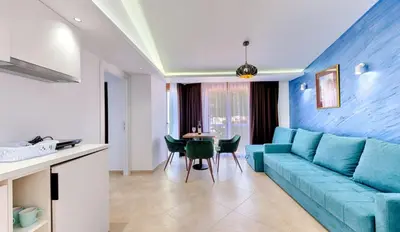 a living room with a blue couch and a table at Lotos - stan 310 in Dobra Voda