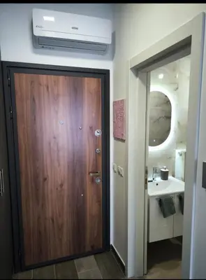 a bathroom with a wooden door and a sink at Bienvenue chez nous studio in Ulcinj