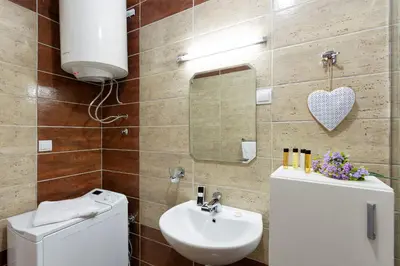 a bathroom with a sink and a toilet and a mirror at Apartments First Line in Petrovac na Moru