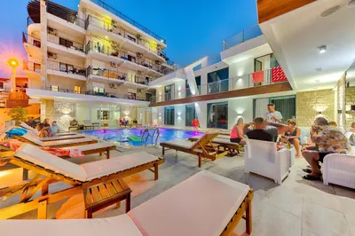 a group of people sitting around a pool in a building at Lotos - stan 318 in Dobra Voda