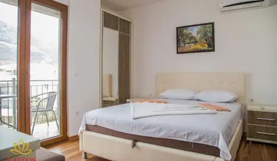 a bedroom with a large bed and a balcony at Lotos - stan 423 in Dobra Voda