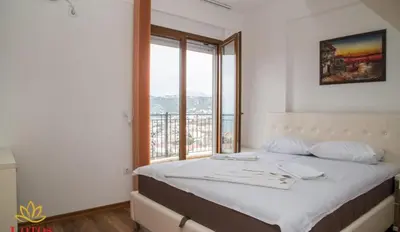 a bedroom with a bed and a large window at Lotos - stan 423 in Dobra Voda