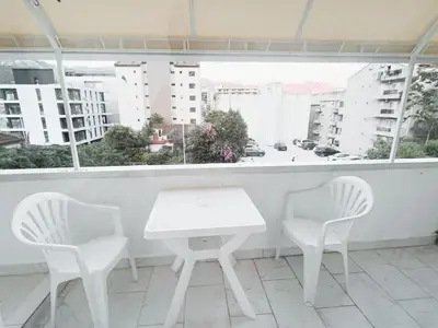 a white table and chairs in a room with a window at Lalic House Budva in Budva