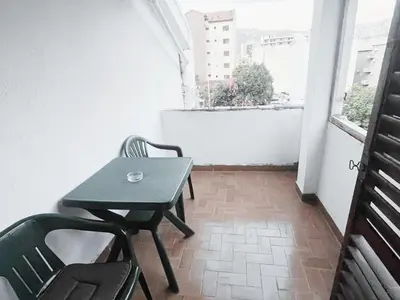 a small table and chairs on a balcony with a window at Lalic House Budva in Budva