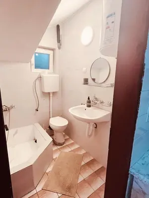 a white bathroom with a sink and a toilet at Lalic House Budva in Budva