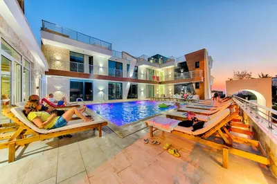 a group of people laying on chairs in a swimming pool at Lotos - stan 106 in Dobra Voda