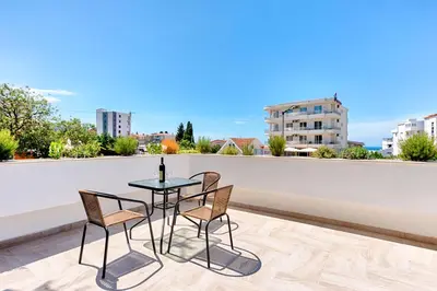 a table and chairs on the roof of a building at Lotos - stan 106 in Dobra Voda