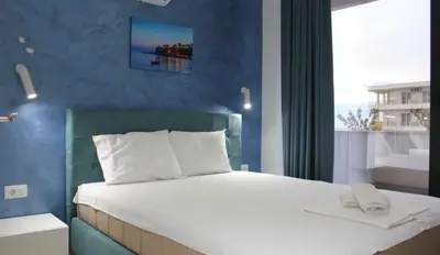 a bedroom with a large bed with a blue wall at Lotos - stan 212 in Dobra Voda
