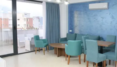 a dining room with blue chairs and a wooden table at Lotos - stan 212 in Dobra Voda