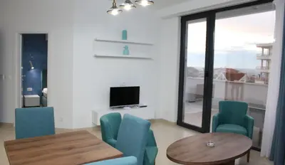 a living room with a table and chairs and a television at Lotos - stan 212 in Dobra Voda