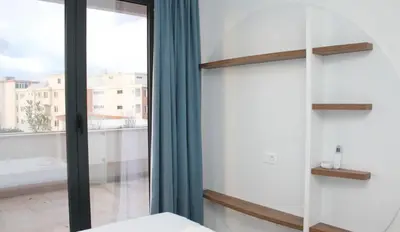 a bedroom with a glass door and a window at Lotos - stan 212 in Dobra Voda