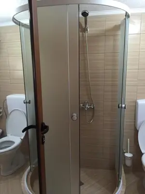 a shower with a glass door in a bathroom with a toilet at Nana Dea in Utjeha