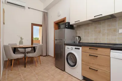 a kitchen with a table and a washer and dryer at MonteHygge apartments in Tivat