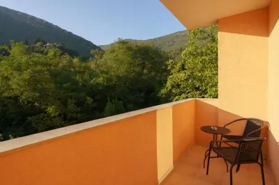 a balcony with two chairs and a table on it at MonteHygge apartments in Tivat