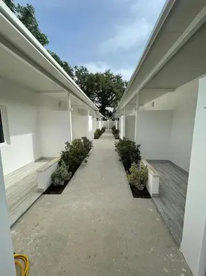 a hallway of a white building with plants on it at Apartmani Alternativa in Biserna Obala