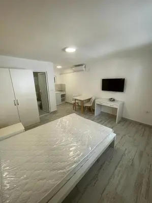 a large white room with a bed and a table at Apartmani Alternativa in Biserna Obala
