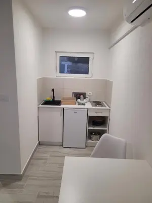 a small kitchen with a sink and a stove at Apartmani Alternativa in Biserna Obala