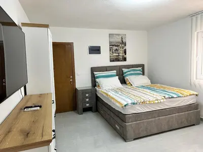 a bedroom with a bed and a television in it at Студия в Добра Вода in Dobra Voda