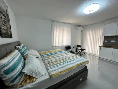 a bedroom with a bed and a kitchen in it at Студия в Добра Вода in Dobra Voda