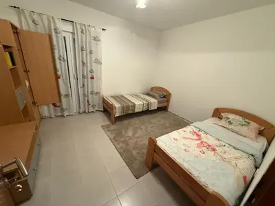 a small bedroom with two beds and a shower at two bedroom apartment with parking in Petrovac na Moru