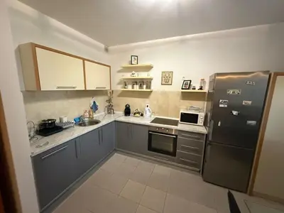 a kitchen with gray cabinets and a black refrigerator at two bedroom apartment with parking in Petrovac na Moru
