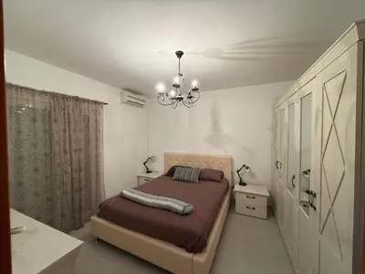 a bedroom with a bed and a chandelier at two bedroom apartment with parking in Petrovac na Moru