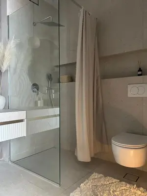 a bathroom with a glass shower and a toilet at Nika in Tivat