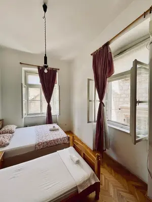 a bedroom with two beds and a window at Private room Shared bathroom and kitchen in Kotor