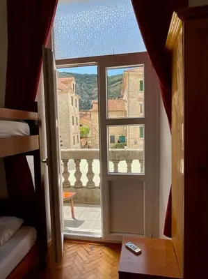 a room with a door open to a balcony at Private room Shared bathroom and kitchen in Kotor