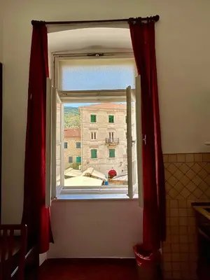 a window with a view of a building at Private room Shared bathroom and kitchen in Kotor