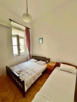 a bedroom with two beds and a window at Private room Shared bathroom and kitchen in Kotor