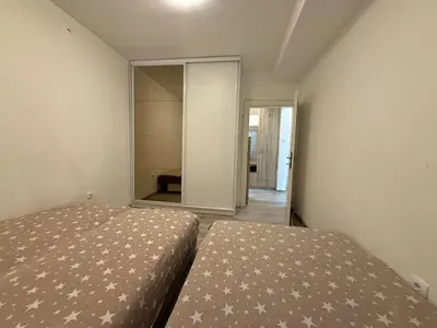 a bedroom with two beds and a mirror at Stan na dan BUDVA in Budva
