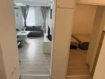 a hallway leading to a living room with a bed at Stan na dan BUDVA in Budva