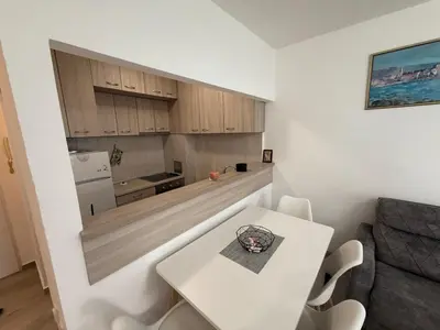 a small kitchen with a white table in a room at Stan na dan BUDVA in Budva