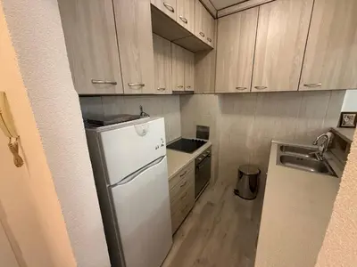 a small kitchen with a refrigerator and a sink at Stan na dan BUDVA in Budva