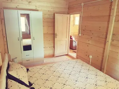 a bedroom with a bed in a room with wooden walls at Sweet one bedroom cottage Ada Bojana - Ulcinj in Ulcinj