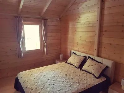 a bedroom with a bed in a log cabin at Sweet one bedroom cottage Ada Bojana - Ulcinj in Ulcinj