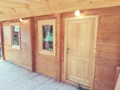 a wooden cabin with a door and two windows at Sweet one bedroom cottage Ada Bojana - Ulcinj in Ulcinj