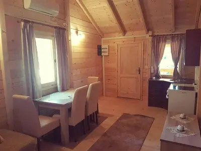 a dining room with a table and chairs and a kitchen at Sweet one bedroom cottage Ada Bojana - Ulcinj in Ulcinj