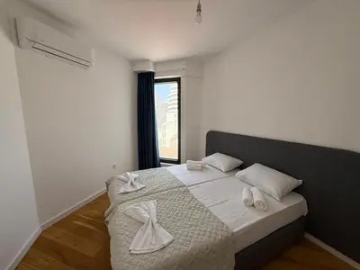 a bedroom with a bed with white towels on it at Lux Apartman Rafailovici in Rafailovici