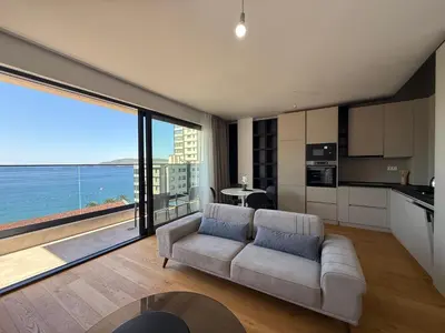 a living room with a couch and a view of the ocean at Lux Apartman Rafailovici in Rafailovici