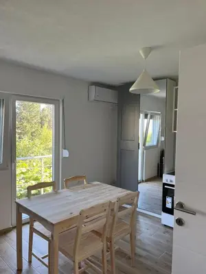 a dining room with a wooden table and chairs at Deskos sea house in Sutomore I floor in Sutomore