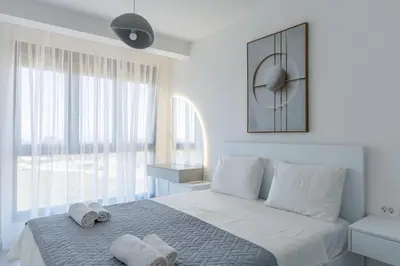 a white bedroom with a bed with towels on it at Casa del Sol Bar in Bar, Susanj