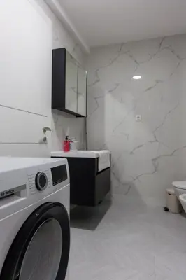 a white laundry room with a washing machine in it at Casa del Sol Bar in Bar, Susanj